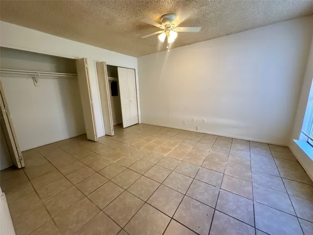 an empty room with a ceiling fan and glass door