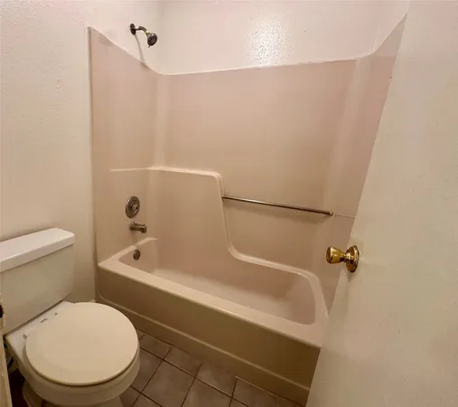 a white toilet sitting next to a bath tub