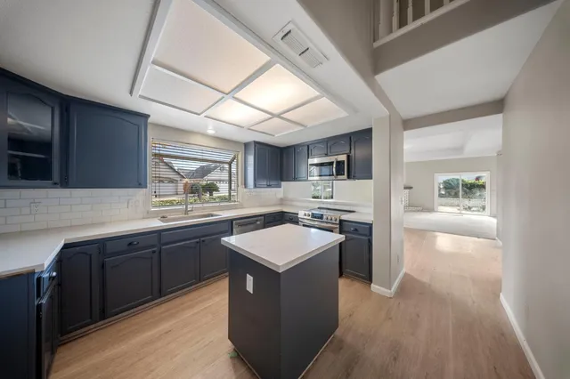 a kitchen with a sink cabinets and wooden floor