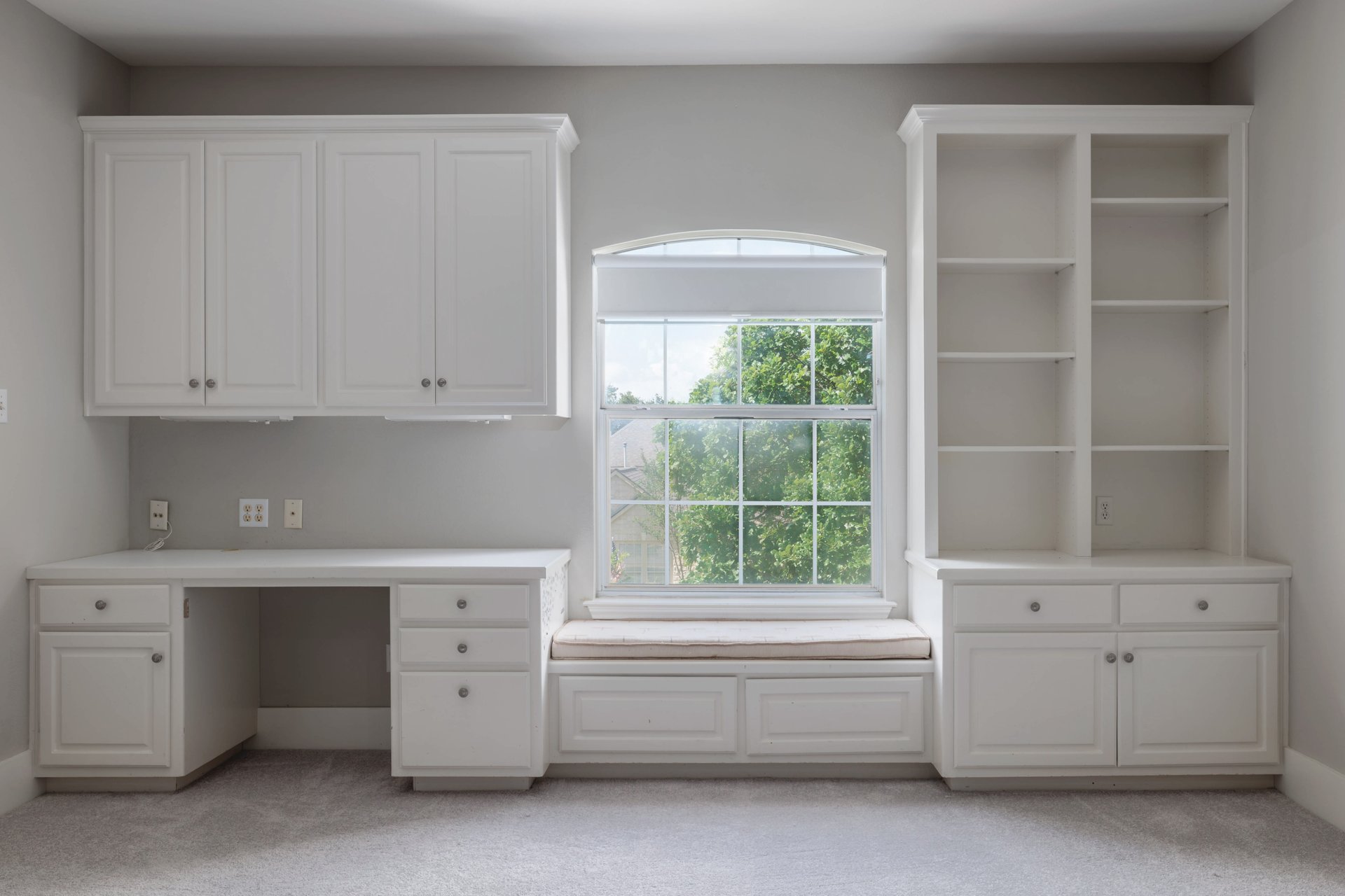 5512 Ballenton Lane Austin, TX 78739 - Photo 27 of 40 An inviting study nook in the loft features built-in desk and shelving, with a cozy window seat overlooking lush greenery.