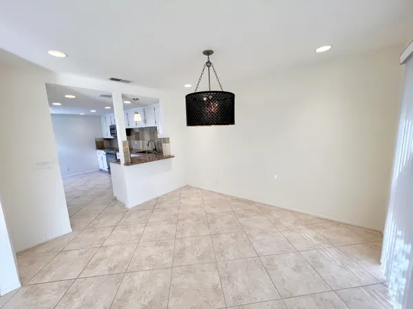 a view of a kitchen with a sink wooden floor and a chandelier