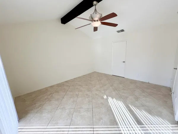 an empty room with a ceiling fan and window
