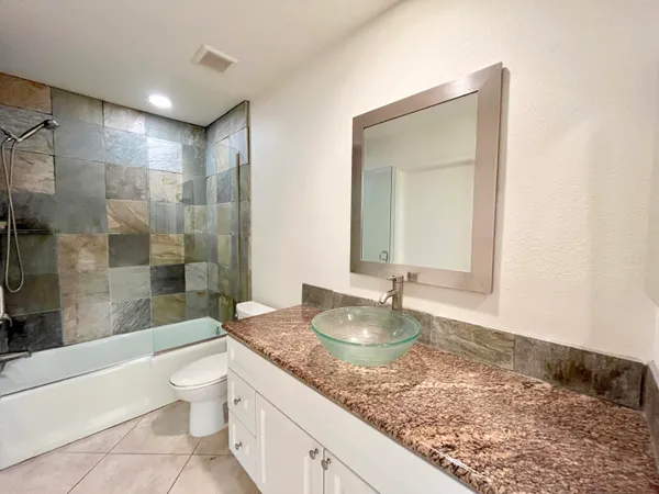 a bathroom with a granite countertop sink and a mirror