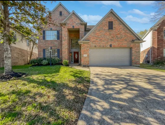 a front view of house with yard and trees in the background