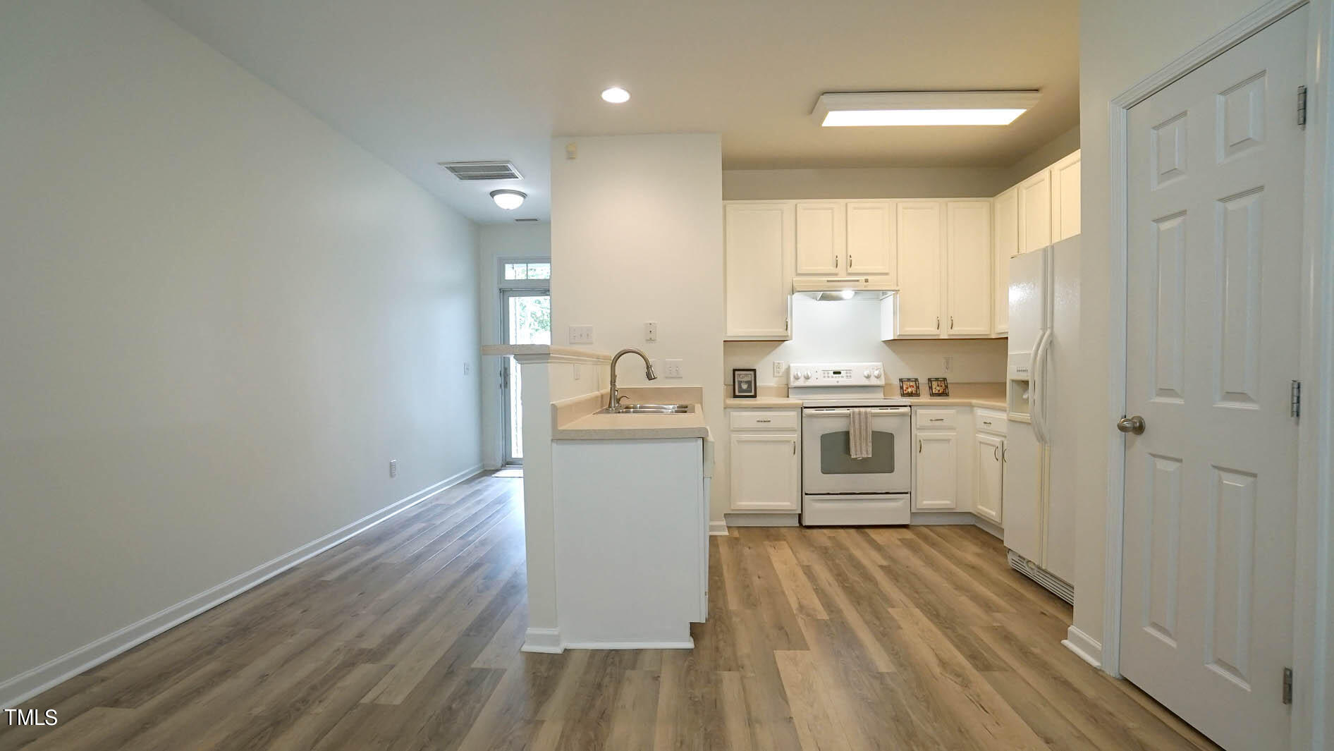 8215 Martello Lane Raleigh, NC 27613 - Photo 3 of 19 a kitchen with white cabinets and white appliances