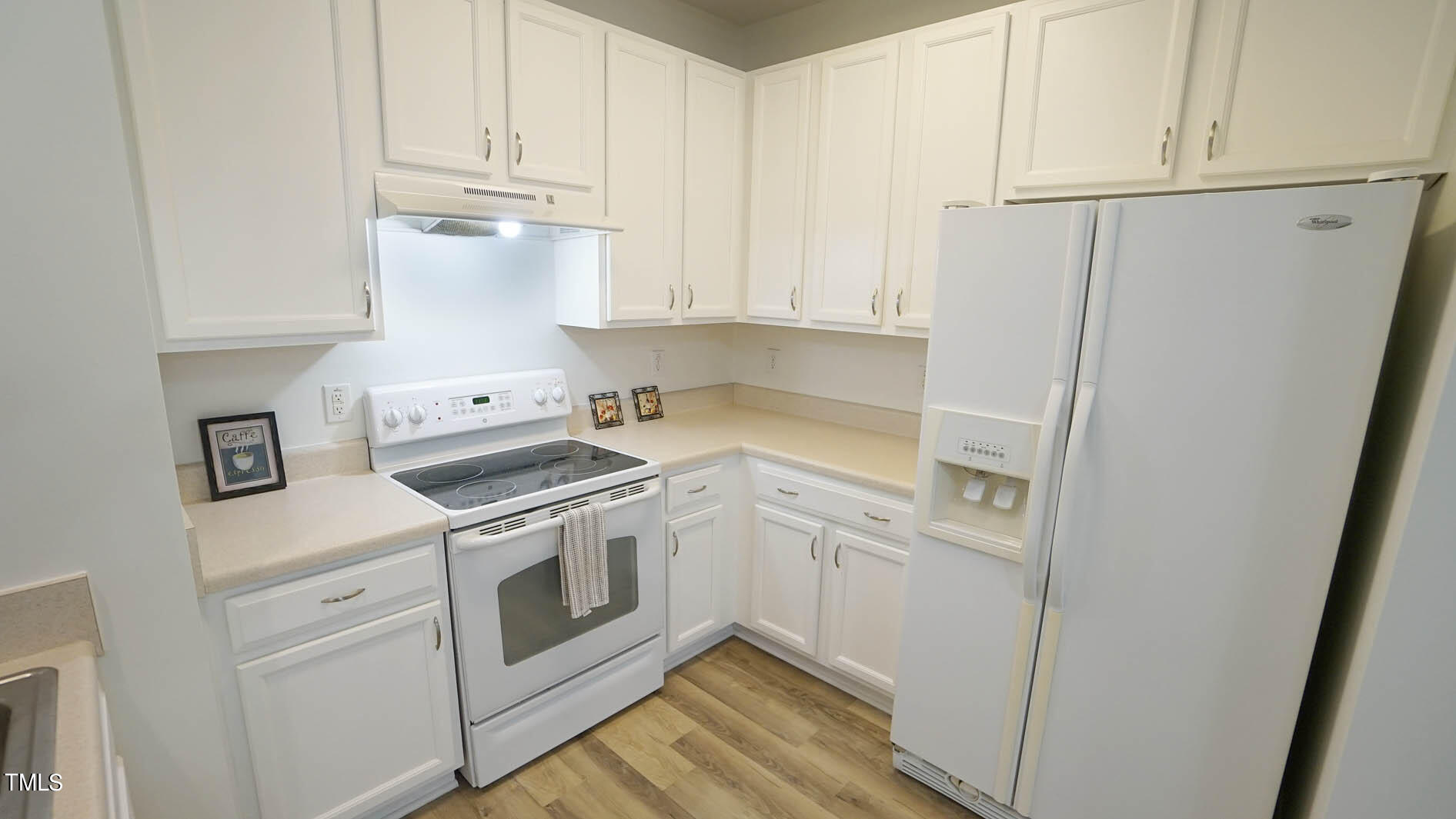 8215 Martello Lane Raleigh, NC 27613 - Photo 6 of 19 a kitchen with white cabinets and white appliances