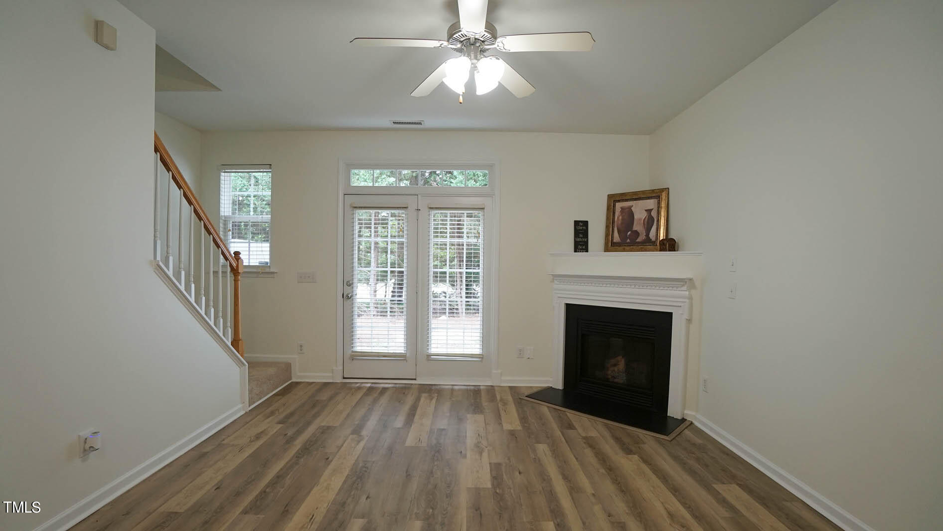 8215 Martello Lane Raleigh, NC 27613 - Photo 7 of 19 a view of an empty room with wooden floor fireplace and a window