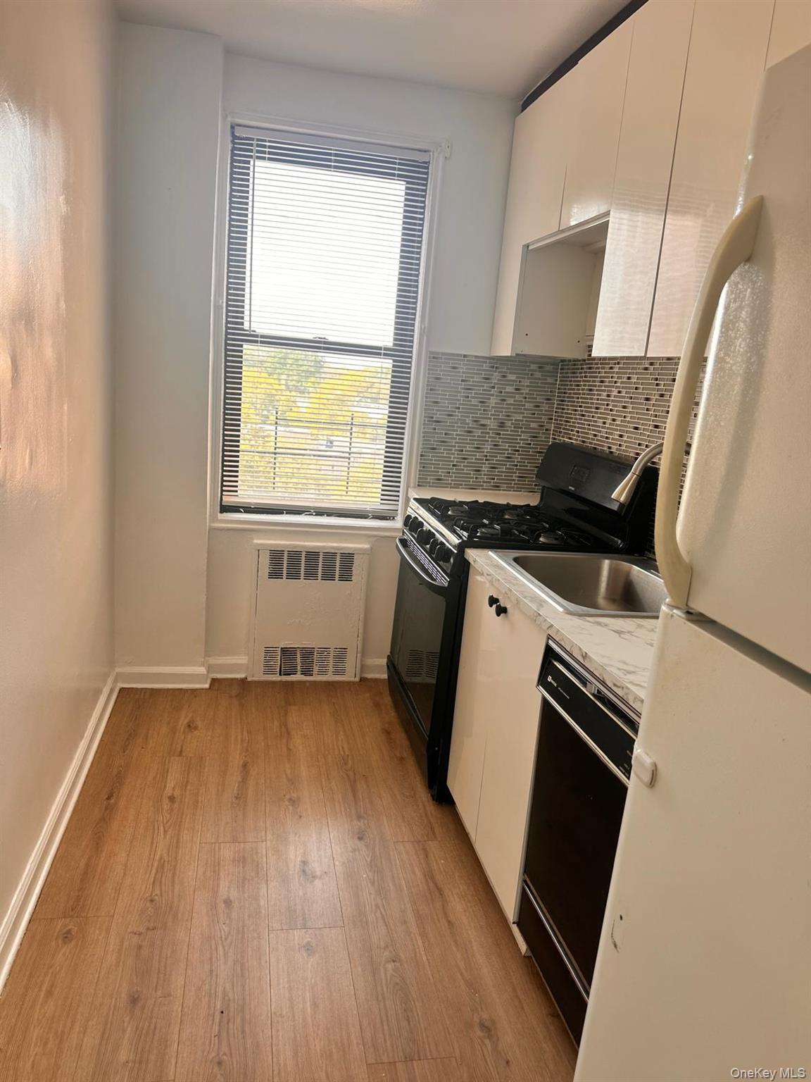 150-11 72nd Road, Unit 6F Queens, NY 11367 - Photo 28 of 31 a kitchen with a wooden floor and a stove top oven