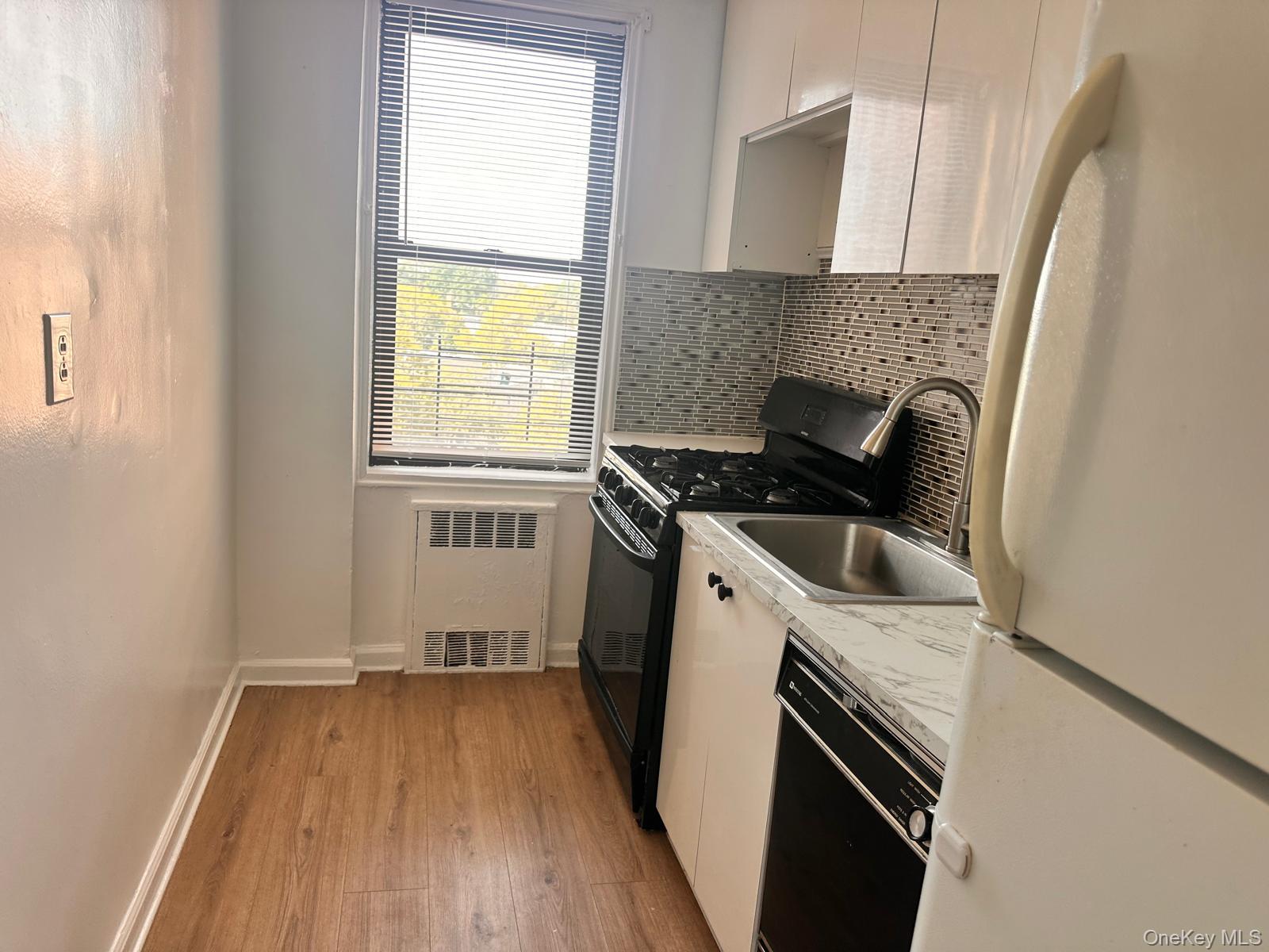 150-11 72nd Road, Unit 6F Queens, NY 11367 - Photo 29 of 31 a kitchen with a sink stove top oven and cabinets