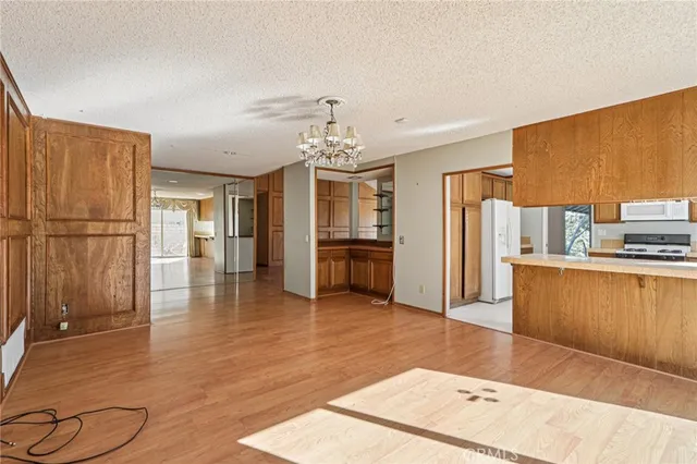 a living room with stainless steel appliances kitchen island granite countertop a refrigerator and a wooden cabinets