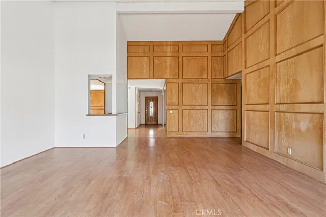 an empty room with wooden floor and natural light