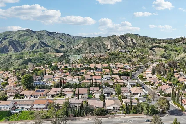 an aerial view of a house with a yard and a large tree