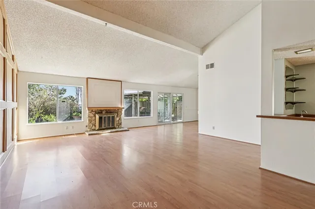 wooden floor fireplace and windows in an empty room