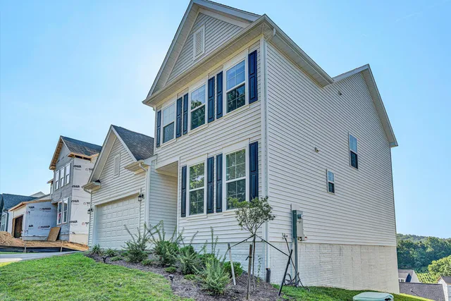 a view of a white house next to a yard