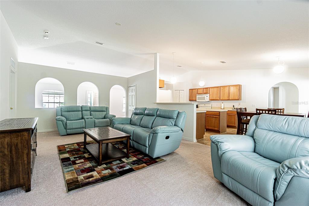 6283 Lorraine Lane Spring Hill, FL 34608 - Photo 4 of 27 a living room with furniture kitchen view and a chandelier