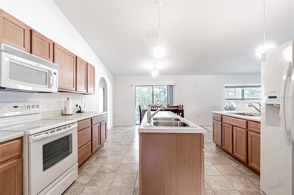 6283 Lorraine Lane Spring Hill, FL 34608 - Photo 6 of 27 a kitchen with stainless steel appliances granite countertop a sink stove refrigerator and cabinets