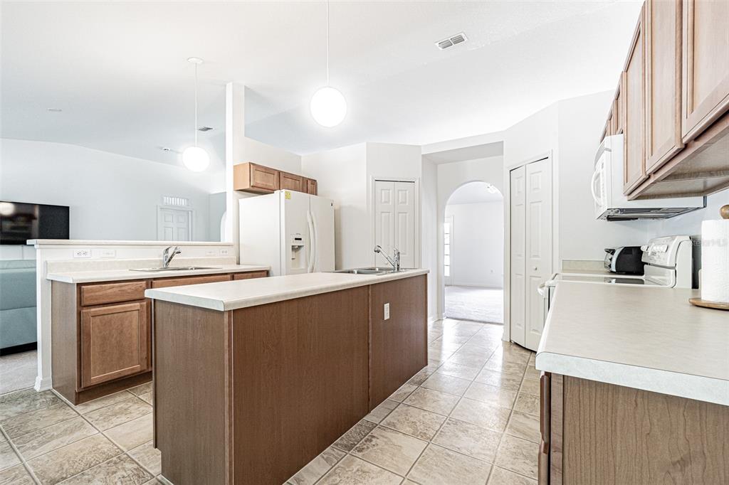 6283 Lorraine Lane Spring Hill, FL 34608 - Photo 7 of 27 a large kitchen with cabinets a sink and a stove