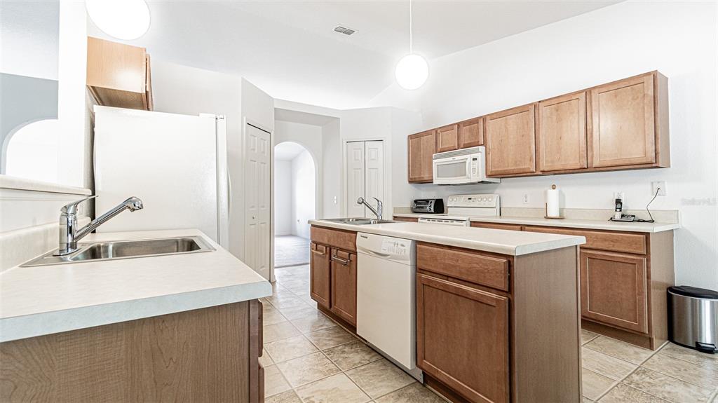 6283 Lorraine Lane Spring Hill, FL 34608 - Photo 8 of 27 a kitchen with stainless steel appliances granite countertop a sink stove and refrigerator