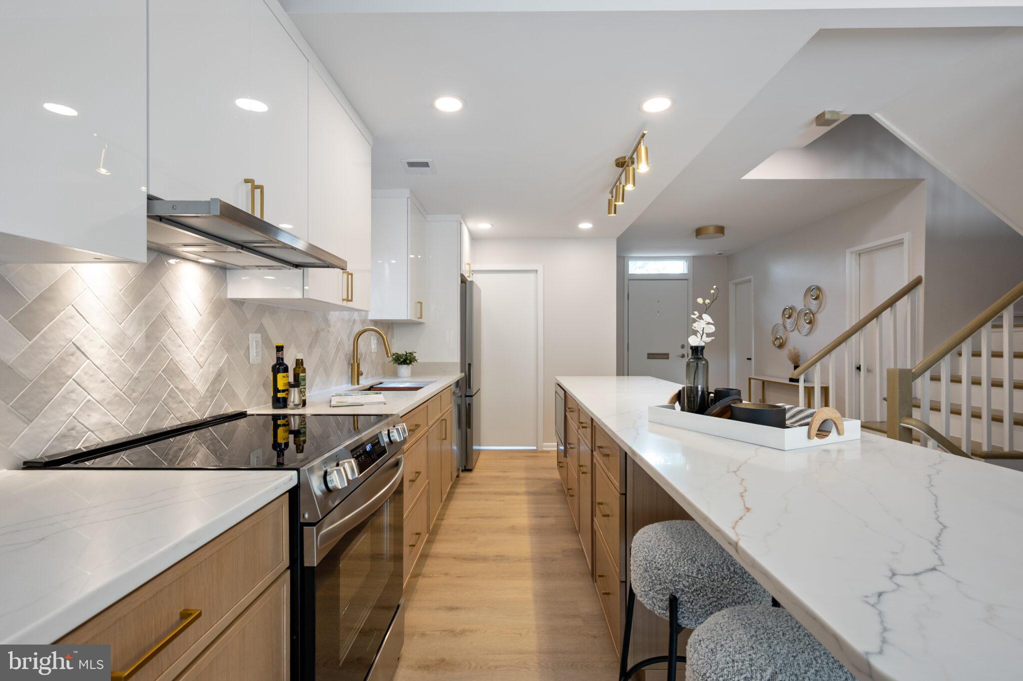 1309 4th Street Southwest, Unit TH9 Washington, DC 20024 - Photo 12 of 63 a kitchen with stainless steel appliances kitchen island a sink stove and cabinets