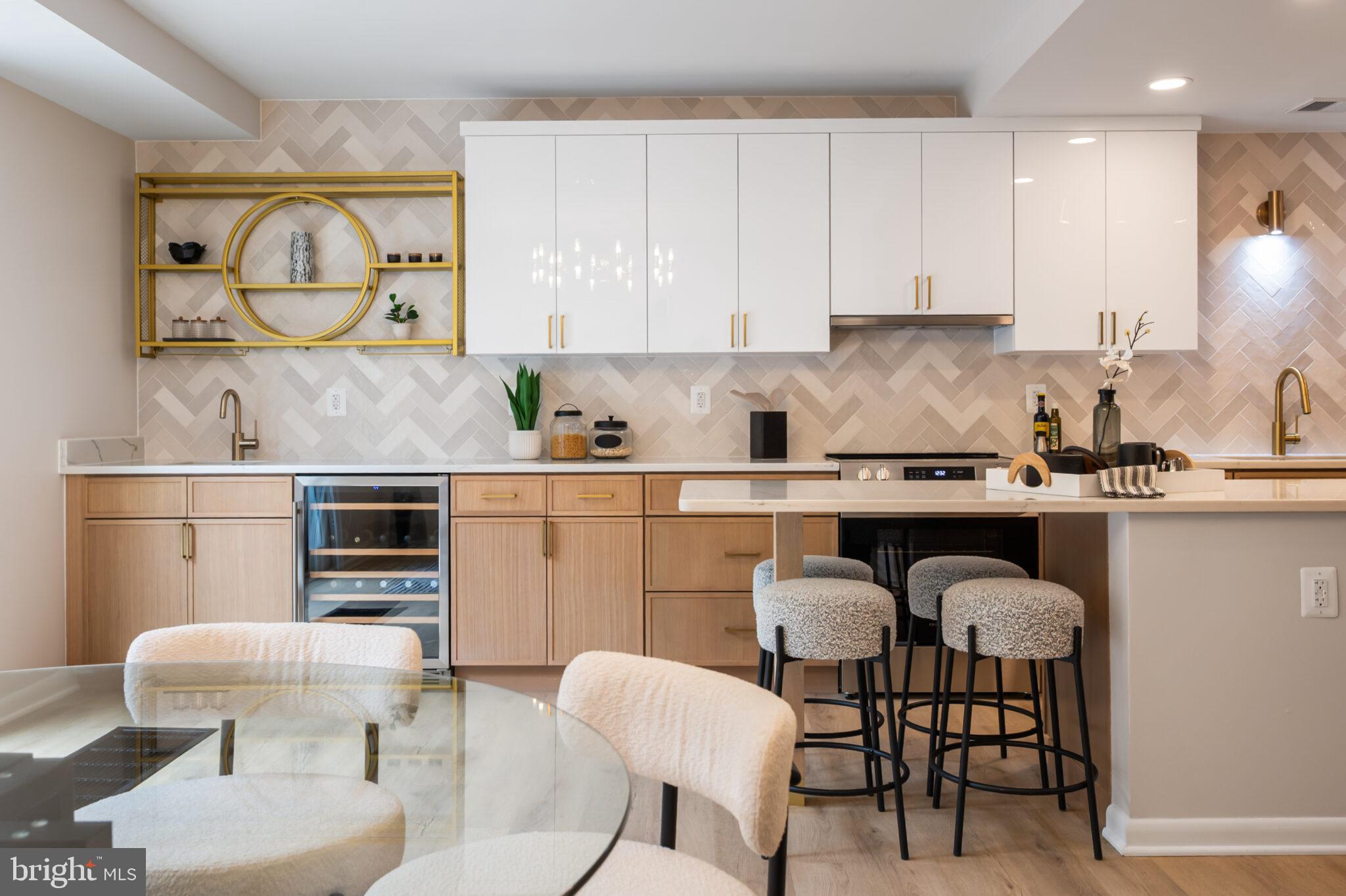 1309 4th Street Southwest, Unit TH9 Washington, DC 20024 - Photo 16 of 63 a kitchen with granite countertop a table chairs stove and white cabinets