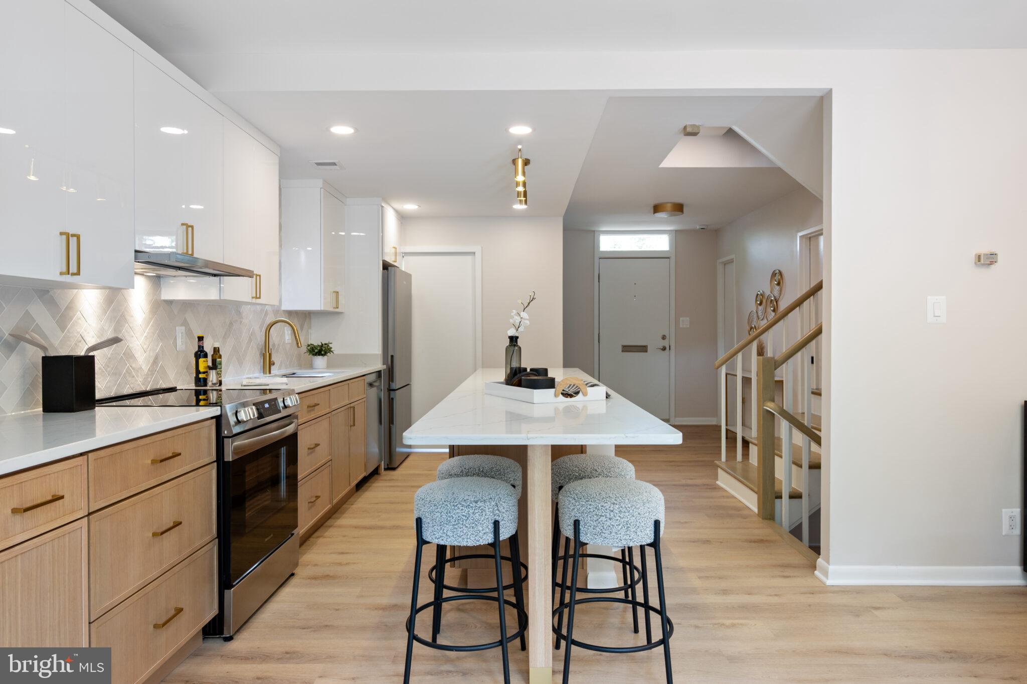 1309 4th Street Southwest, Unit TH9 Washington, DC 20024 - Photo 10 of 63 a kitchen with stainless steel appliances kitchen island hardwood floor stove sink and cabinets