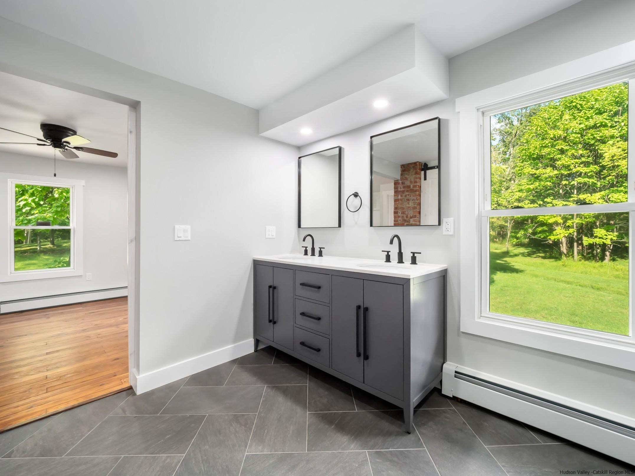 37 Towpath Road Accord, NY 12404 - Photo 17 of 29 a spacious bathroom with a double vanity sink a mirror and a bathtub next to a window