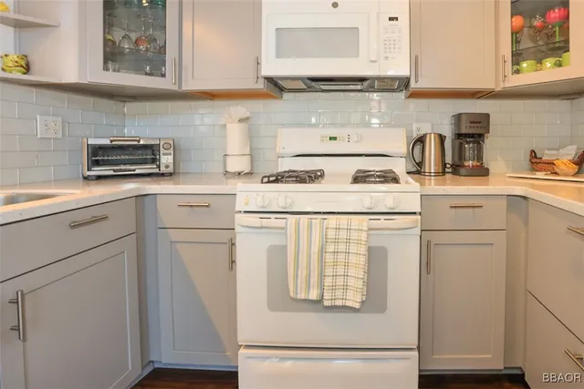 a kitchen with white cabinets and white appliances