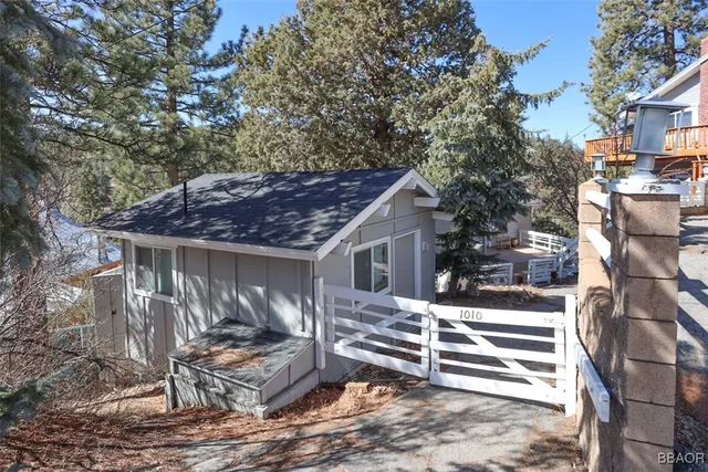 a view of a house with backyard and wooden fence
