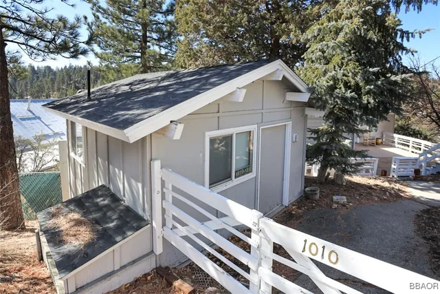 a view of a house with a small yard plants and large tree