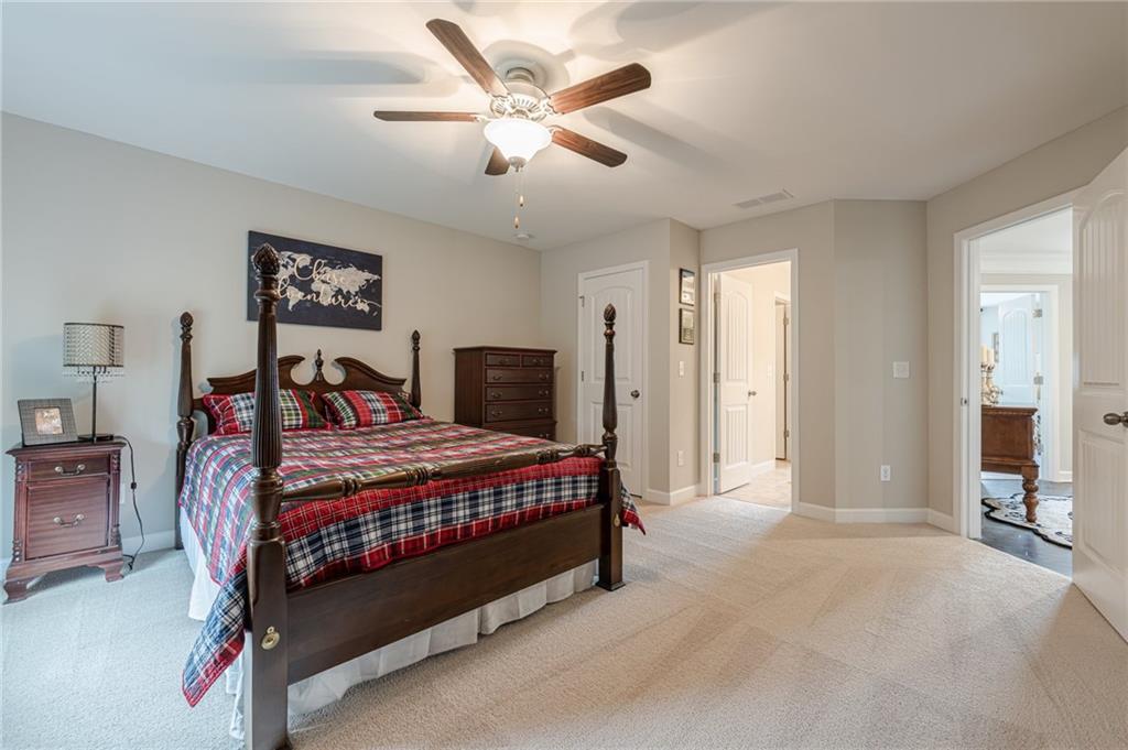 5515 Cheatam Avenue Cumming, GA 30040 - Photo 54 of 99 a bedroom with a large bed and a chandelier