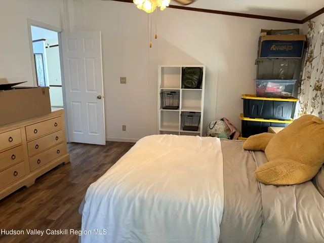 a bedroom with a bed and a flat tv screen on dresser