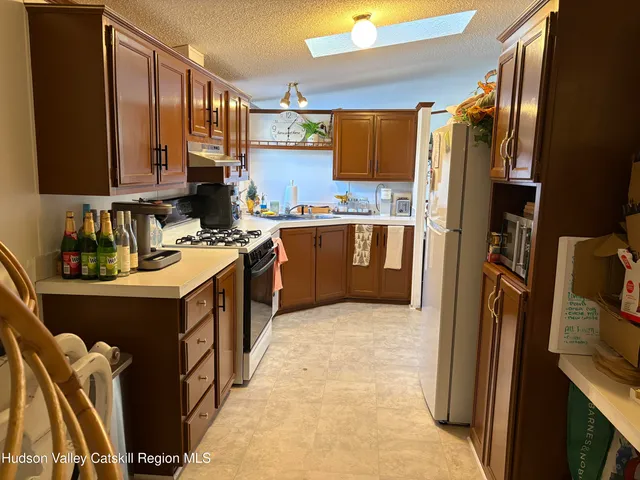 a kitchen with stainless steel appliances granite countertop a refrigerator a stove a sink and a microwave