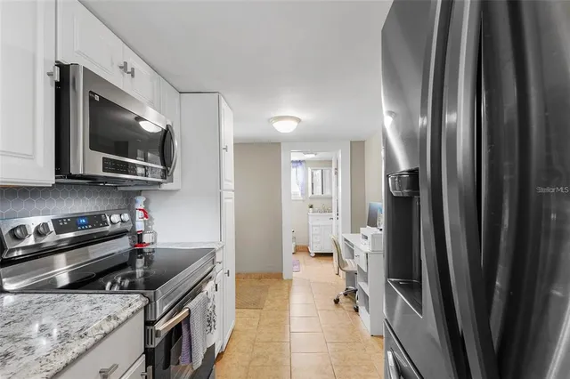 a kitchen with stainless steel appliances granite countertop a refrigerator and a stove top oven