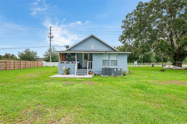a view of a house with a big yard and sitting area
