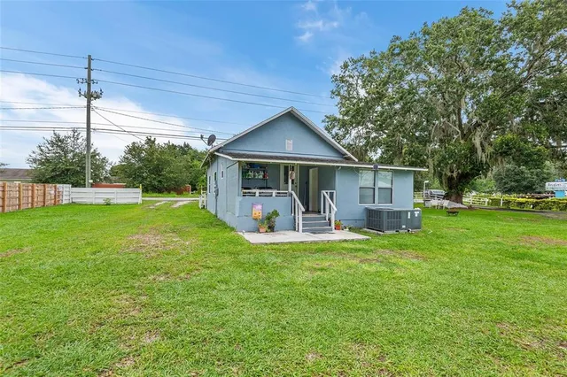 a view of a house with a patio and a yard