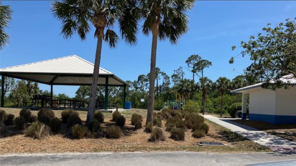 13232 Kitchener Avenue Port Charlotte, FL 33981 - Photo 5 of 5 a view of a patio with a table and chairs under an umbrella