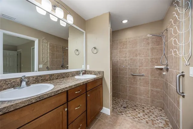 a bathroom with a granite countertop sink a mirror a glass door shower and a mirror