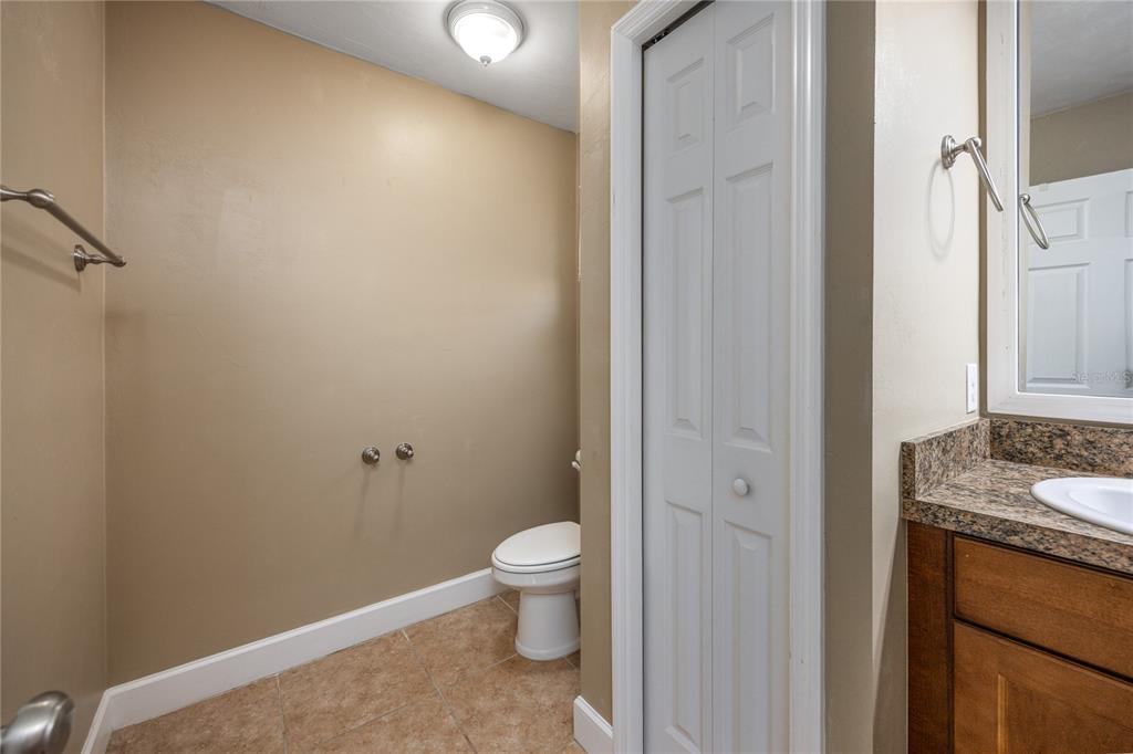 470 Southwest 251st Street Newberry, FL 32669 - Photo 20 of 33 a bathroom with a granite countertop sink a toilet and a mirror