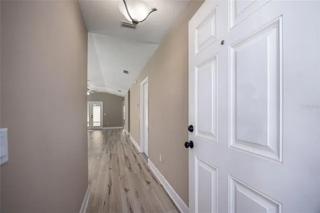 a view of a hallway with wooden floor and staircase