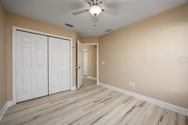 a view of a room with wooden floor and a ceiling fan