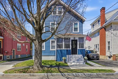 a front view of a house with a tree
