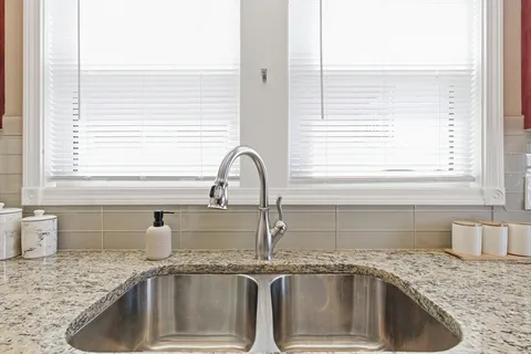 a kitchen with granite countertop a sink and a window