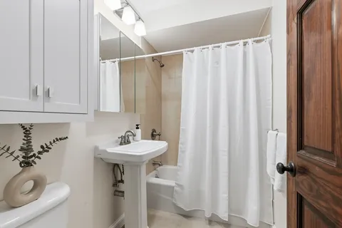 a bathroom with a sink a mirror and a shower curtain