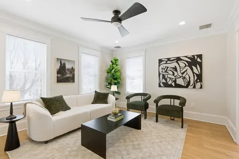 a living room with furniture and a painting on the wall