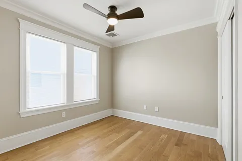 an empty room with a window and a fan