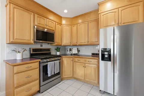 a kitchen with stainless steel appliances granite countertop a refrigerator stove microwave and sink