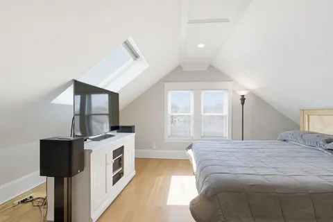 a spacious bedroom with a bed and a chandelier
