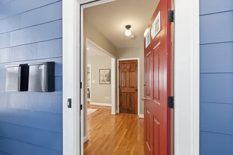 a view of a hallway with wooden floor and cabinets