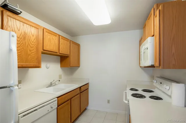 a kitchen with a sink a refrigerator and cabinets