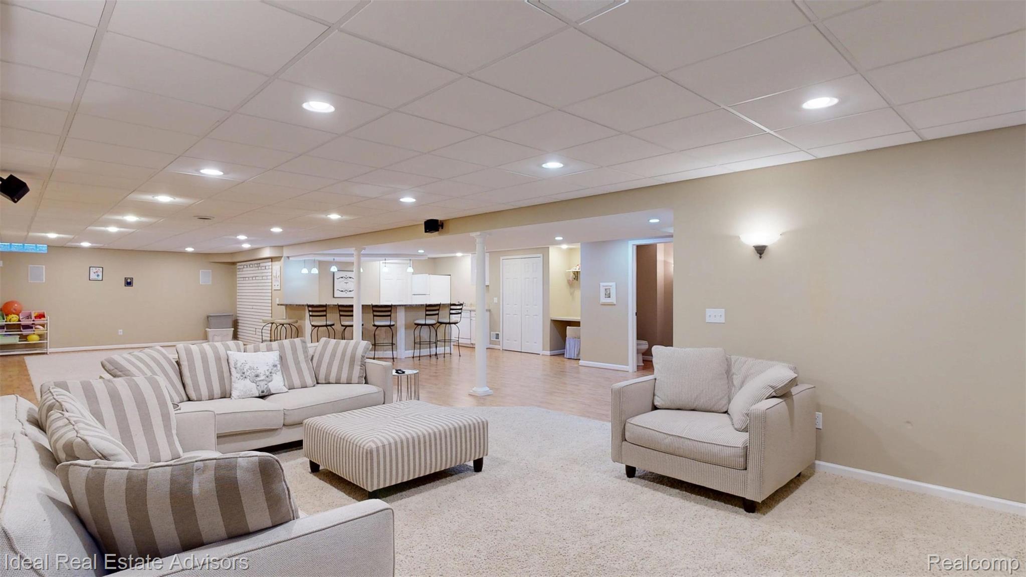 1364 Kentfield Drive Rochester, MI 48307 - Photo 61 of 70 Spacious lower level featuring a combination of carpet and wood-finish flooring, recessed lighting, and a built-in wet bar with a countertop and under-counter cabinetry